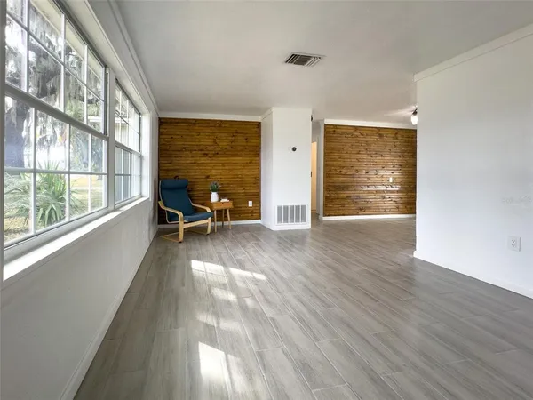 an empty room with wooden floor and furniture