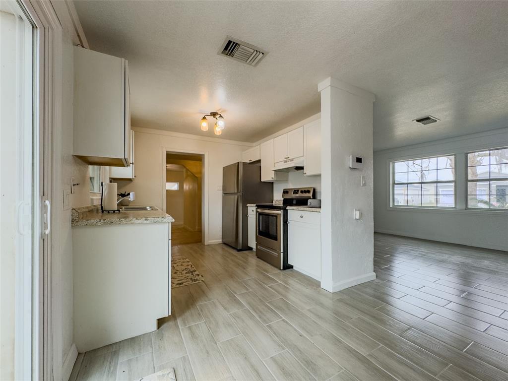 1047 Clay Boulevard Eustis, FL 32726 - Photo 8 of 33 a kitchen with a refrigerator and a stove top oven