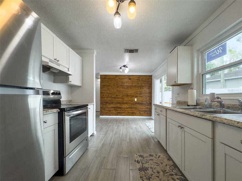 1047 Clay Boulevard Eustis, FL 32726 - Photo 9 of 33 a kitchen with granite countertop a sink cabinets stainless steel appliances and a window