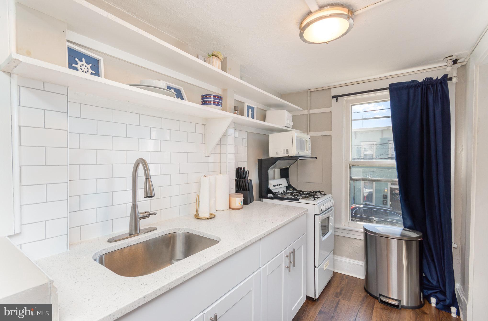126 Prince George Street, Unit 4 Annapolis, MD 21401 - Photo 6 of 12 a kitchen with a sink dishwasher a stove and a refrigerator with wooden floor