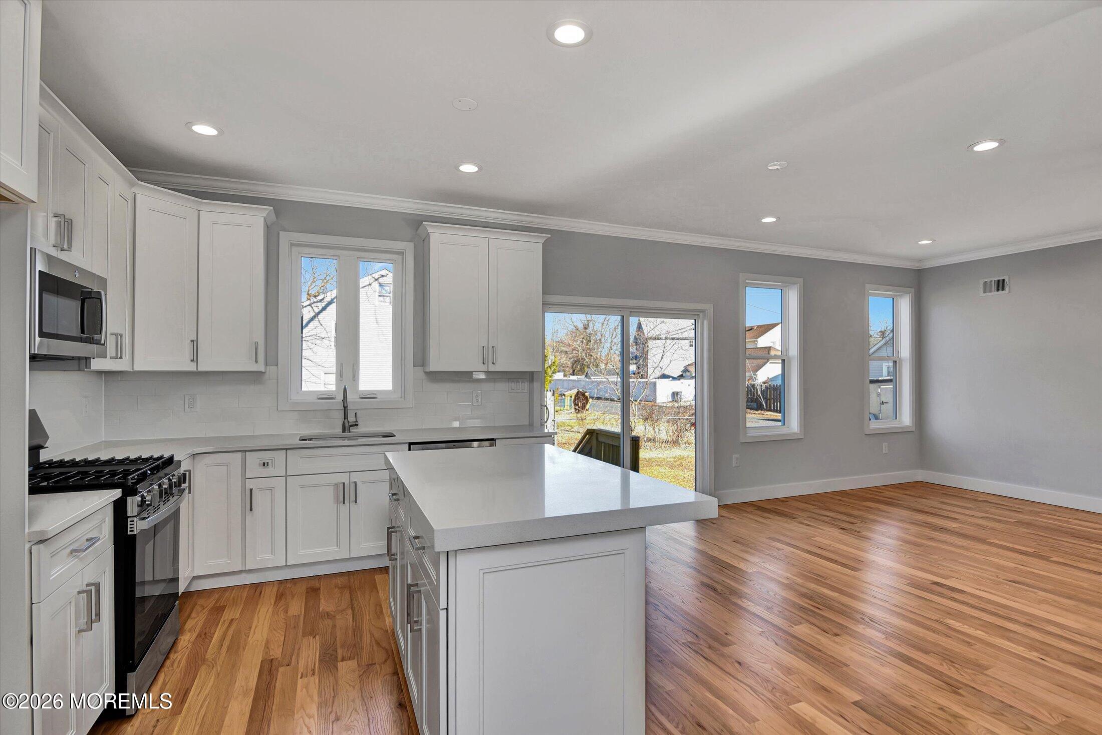 910 Malden Drive Keyport, NJ 07735 - Photo 14 of 38 a large kitchen with stainless steel appliances granite countertop a lot of counter space and wooden floor