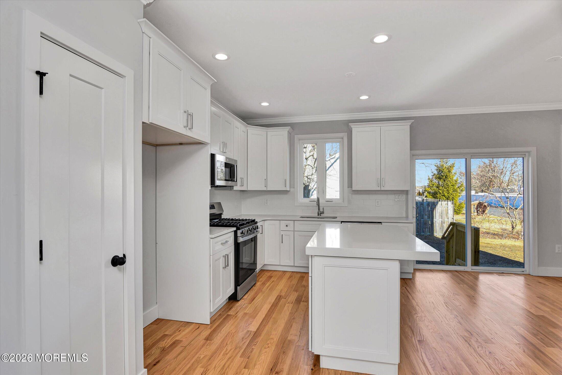 910 Malden Drive Keyport, NJ 07735 - Photo 15 of 38 a kitchen with stainless steel appliances granite countertop a refrigerator a stove and a wooden floors