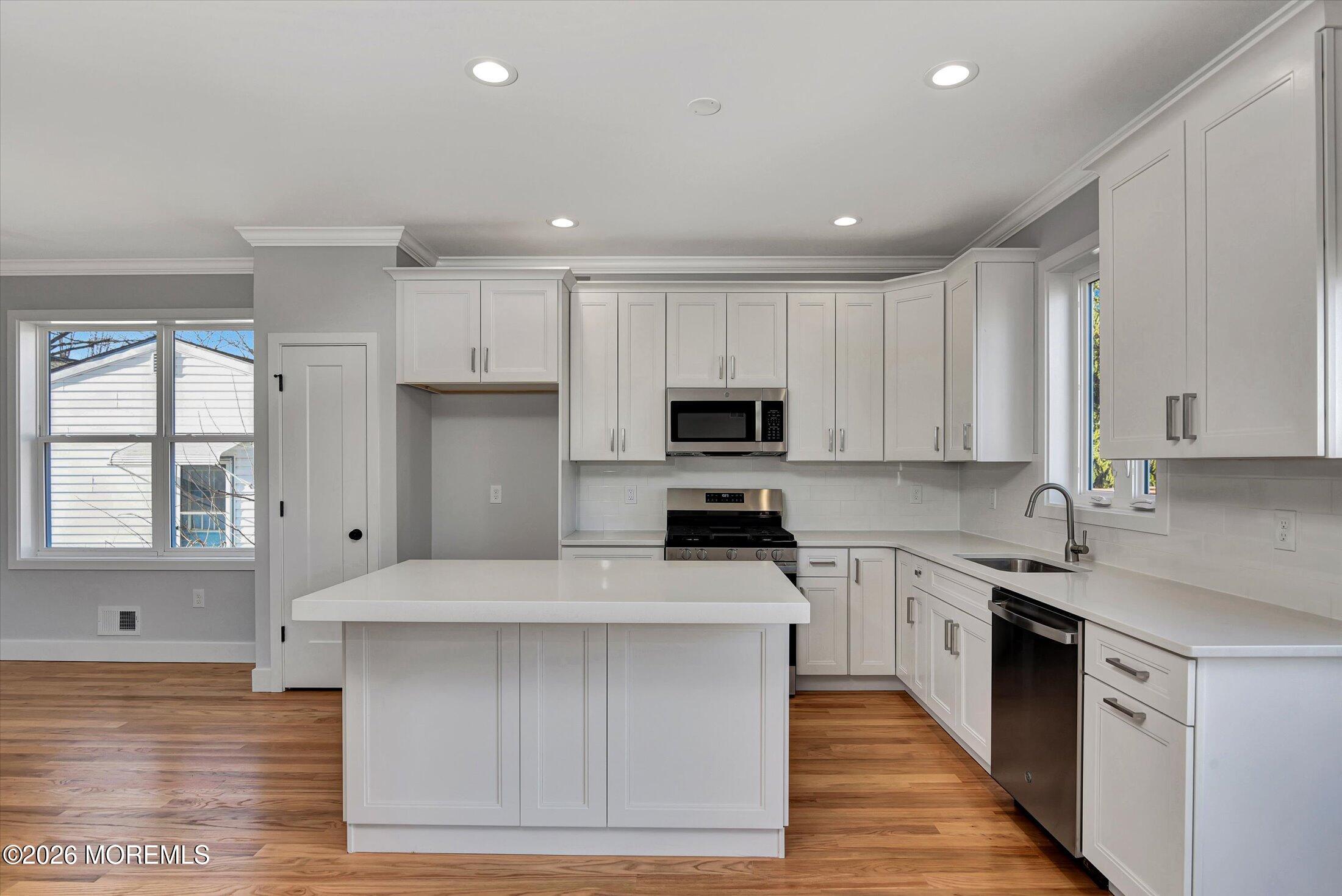 910 Malden Drive Keyport, NJ 07735 - Photo 17 of 38 a kitchen with stainless steel appliances kitchen island granite countertop a sink a stove top oven a refrigerator and cabinets