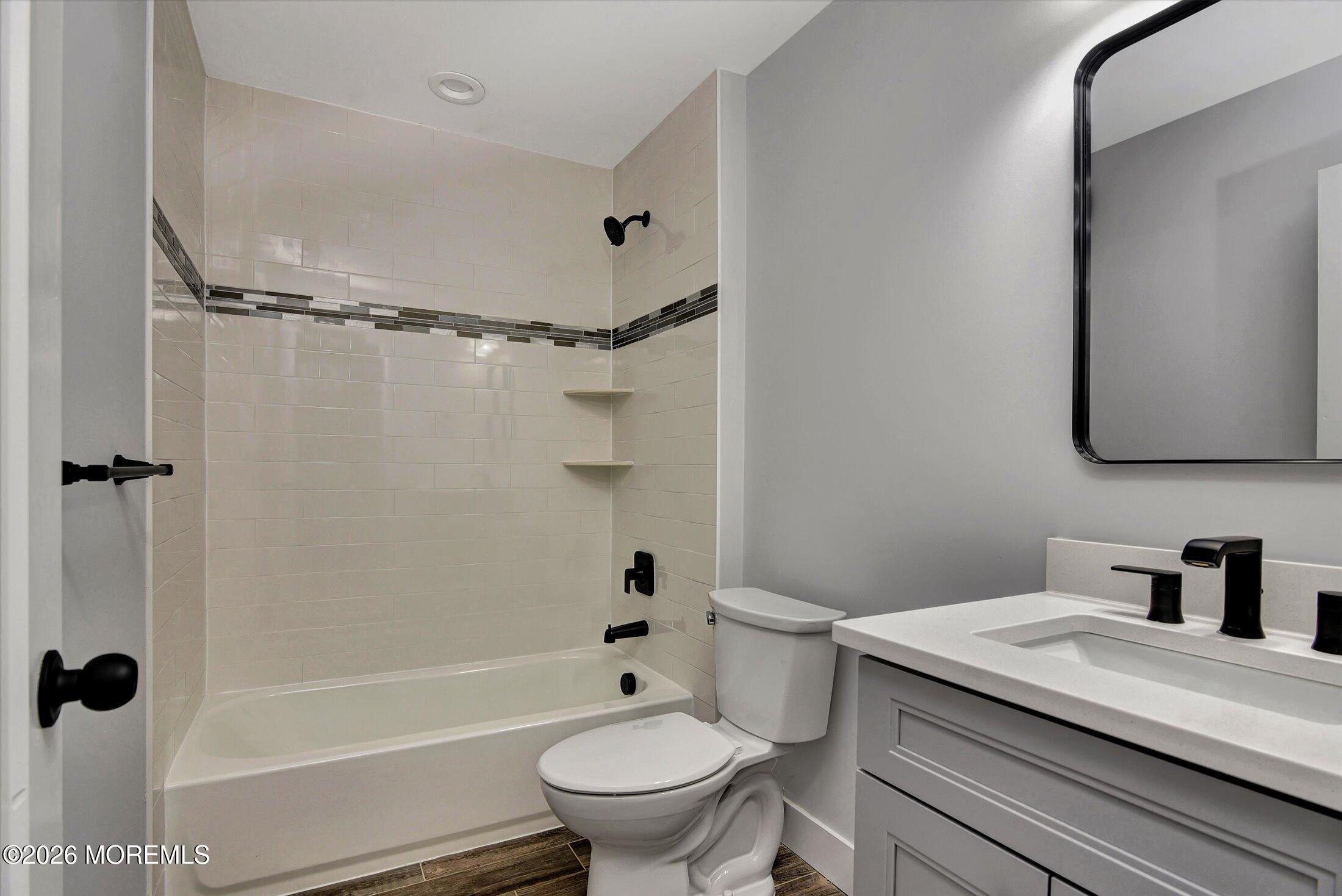 910 Malden Drive Keyport, NJ 07735 - Photo 25 of 38 a bathroom with a granite countertop toilet a sink and a bathtub