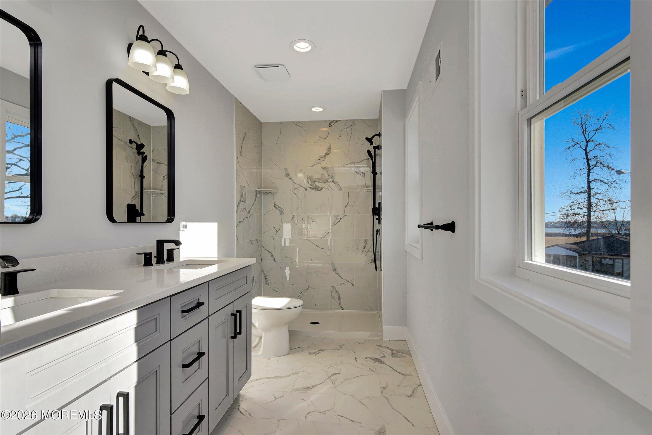 910 Malden Drive Keyport, NJ 07735 - Photo 30 of 38 a bathroom with a double vanity sink toilet mirror and shower