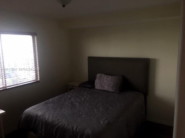 816 Northwest 11th Street, Unit 1104 Miami, FL 33136 - Photo 6 of 7 a bed sitting in a bedroom next to a window