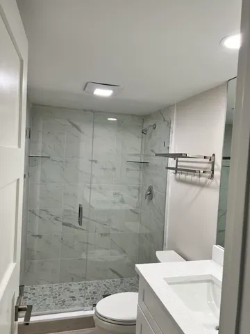 a bathroom with a sink a toilet and shower