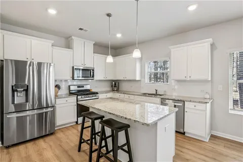 a kitchen with a center island appliances and cabinets