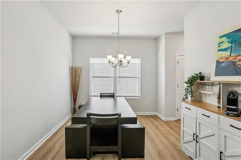 a view of a dining room with furniture a chandelier and wooden floor