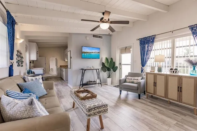 a living room with furniture a ceiling fan and a window