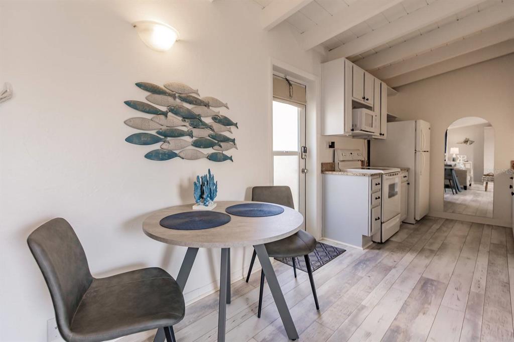 6006 Midnight Pass Road, Unit 10 Sarasota, FL 34242 - Photo 8 of 20 a kitchen with stainless steel appliances granite countertop a dining table chairs and a refrigerator
