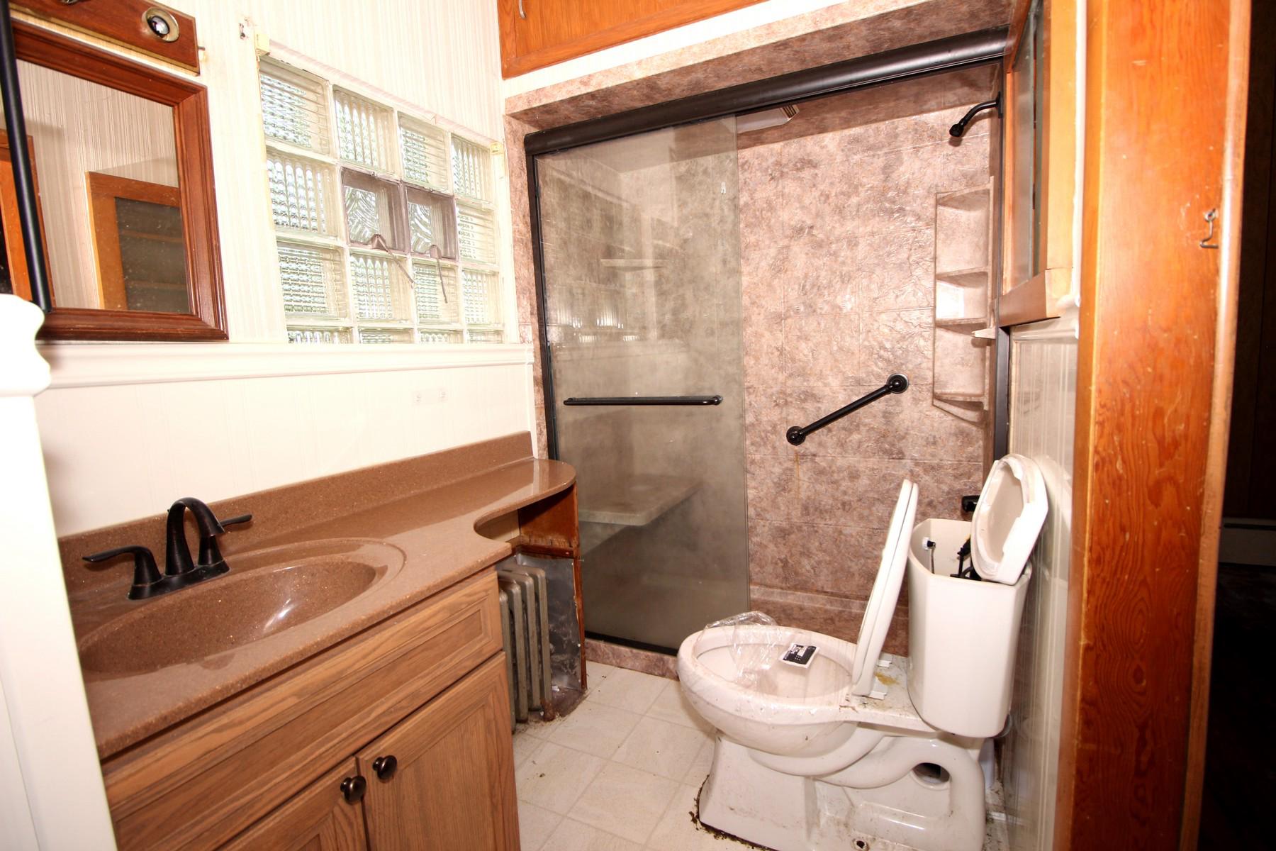 108 Mill Street Lock Haven, PA 17745 - Photo 16 of 26 a bathroom with a sink a toilet a mirror and shower
