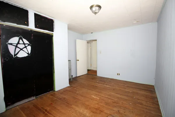 an empty room with wooden floor and a window