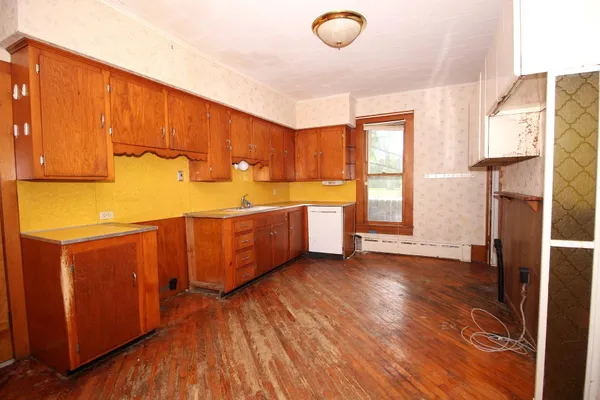 a view of a kitchen with wooden floor and electronic appliances