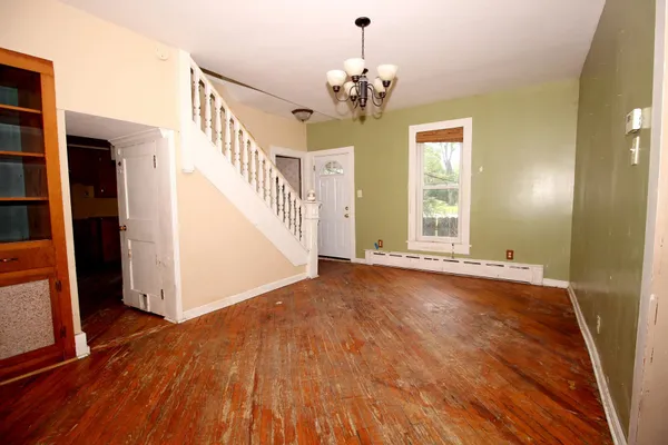 a view of a livingroom with wooden floor and staircase