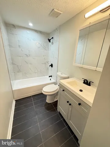 a bathroom with a sink a toilet and bathtub