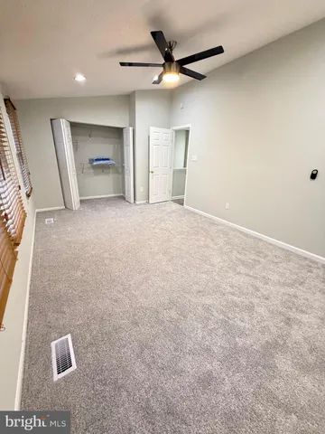 en empty room with windows and ceiling fan