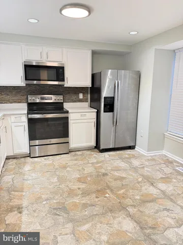 a kitchen with stainless steel appliances a stove a microwave and a refrigerator