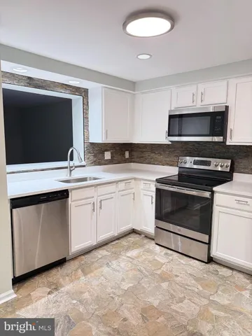 a kitchen with granite countertop a sink and a stove