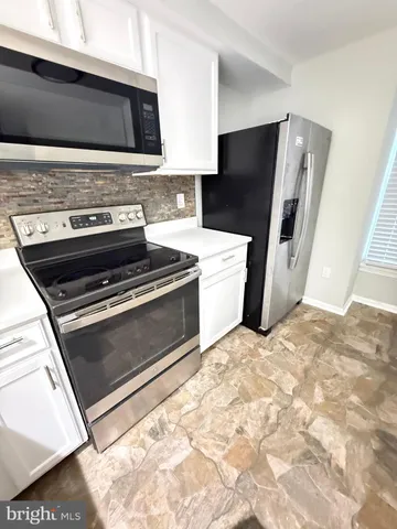 a kitchen with granite countertop a stove and a refrigerator