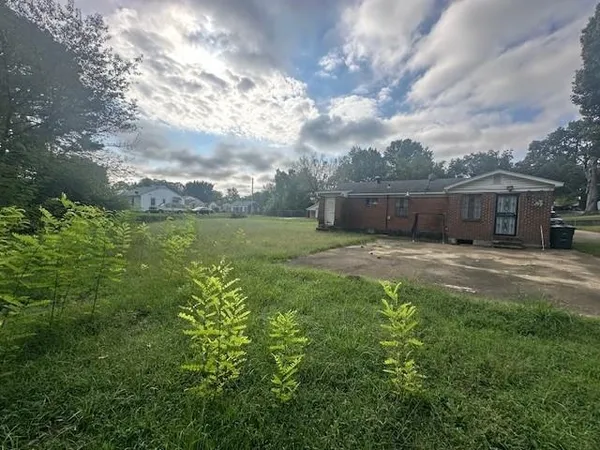 a view of a house with a yard and sitting area