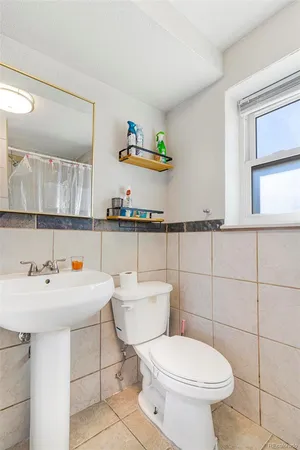 a bathroom with a sink a toilet and a mirror