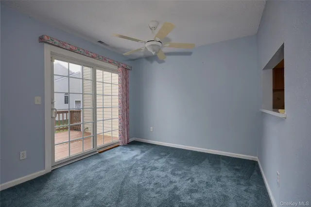 a view of an empty room with a chandelier fan