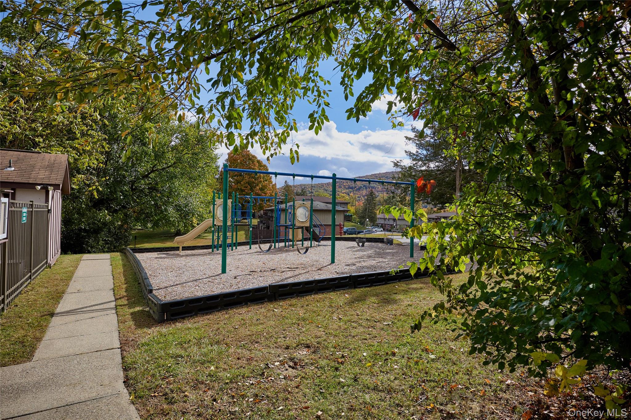 43 Spruce Ridge Drive Fishkill, NY 12524 - Photo 41 of 44 a view of a patio with couches table and chairs under an umbrella