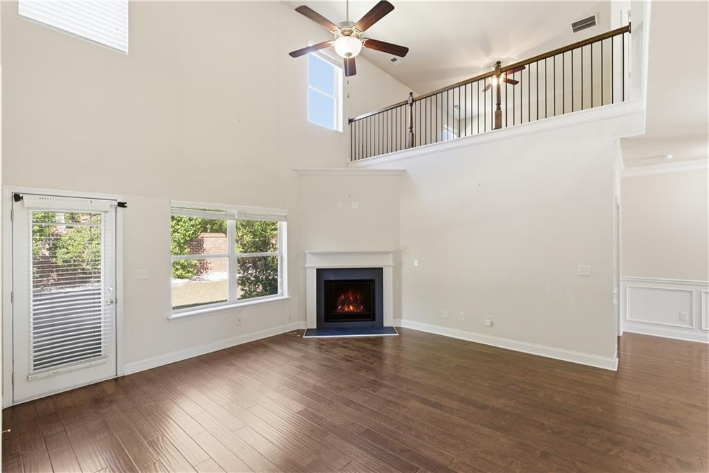 2573 Madison Mae Lane Grayson, GA 30017 - Photo 14 of 51 an empty room with wooden floor fireplace and windows