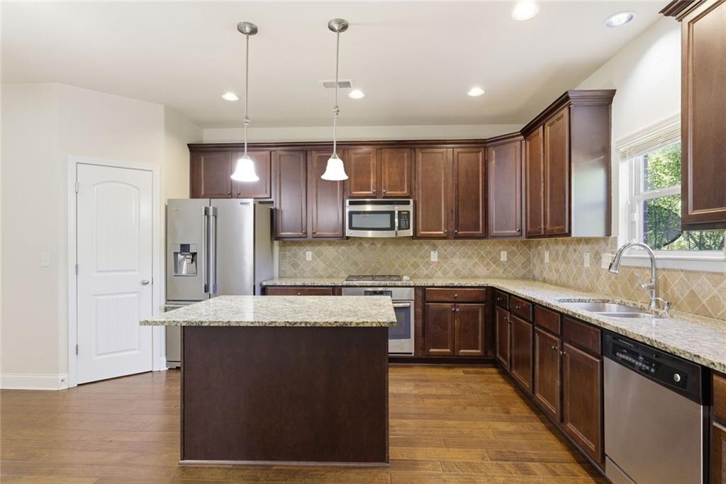 2573 Madison Mae Lane Grayson, GA 30017 - Photo 19 of 51 a kitchen with stainless steel appliances granite countertop a sink stove and refrigerator