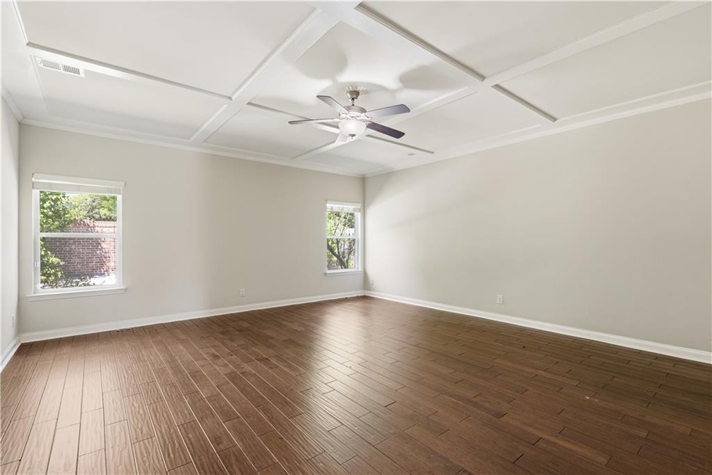 2573 Madison Mae Lane Grayson, GA 30017 - Photo 25 of 51 an empty room with wooden floor chandelier fan and windows