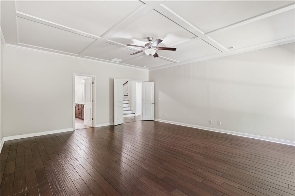 2573 Madison Mae Lane Grayson, GA 30017 - Photo 26 of 51 an empty room with wooden floor ceiling fan and windows