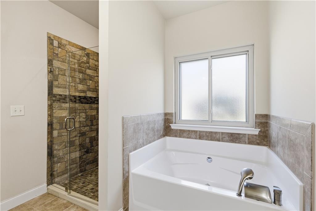 2573 Madison Mae Lane Grayson, GA 30017 - Photo 29 of 51 a bathroom with a bathtub and shower