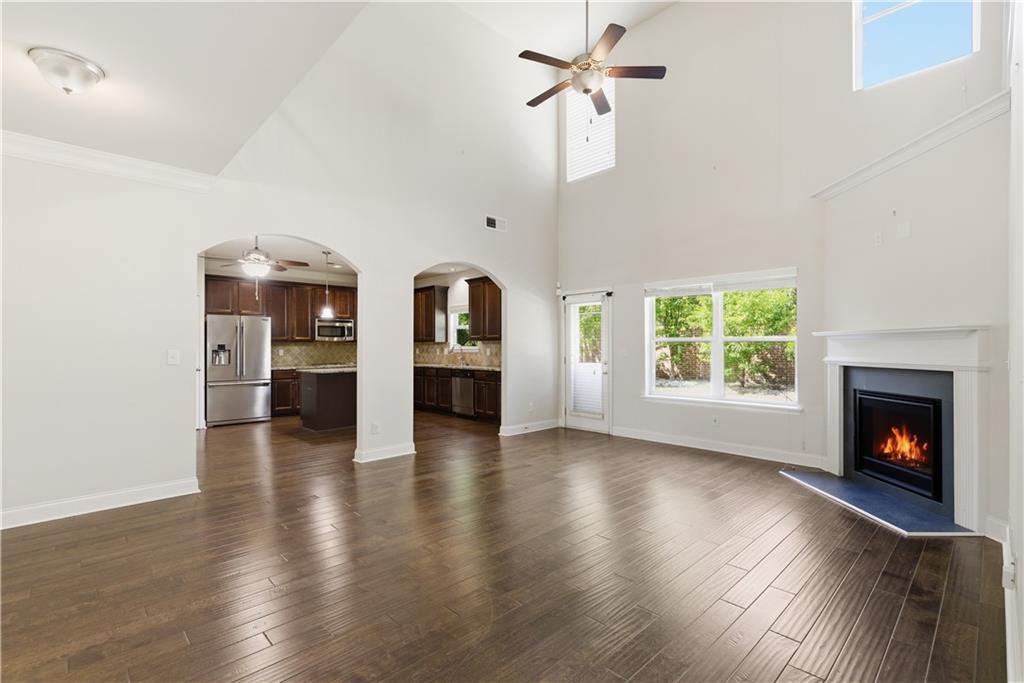2573 Madison Mae Lane Grayson, GA 30017 - Photo 31 of 51 an empty room with wooden floor fireplace and windows