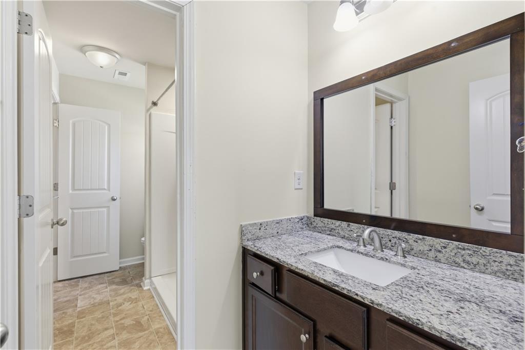2573 Madison Mae Lane Grayson, GA 30017 - Photo 44 of 51 a bathroom with a granite countertop sink and a mirror
