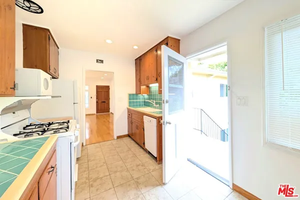 a kitchen with stainless steel appliances granite countertop a refrigerator and a stove
