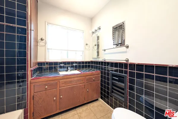 a bathroom with a granite countertop sink a toilet and mirror