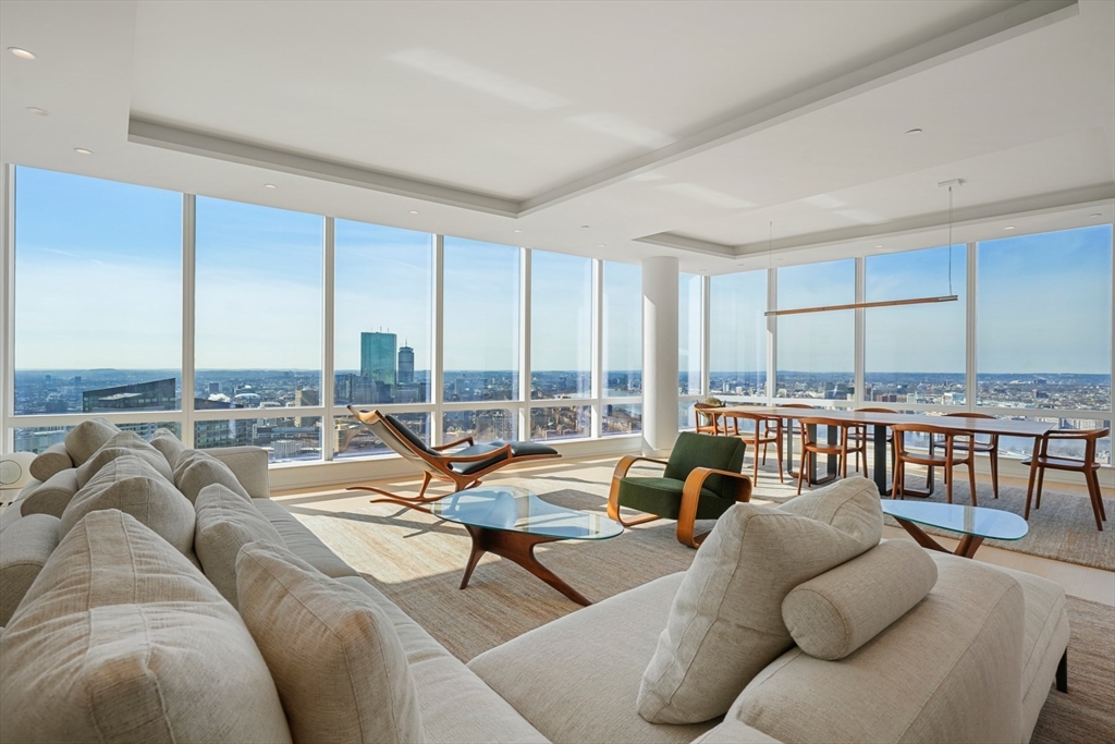 a living room with furniture and floor to ceiling windows