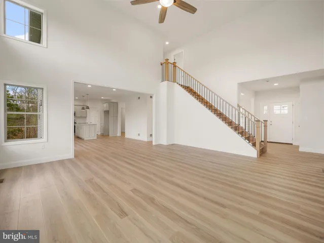 a view of empty room with wooden floor and chandelier