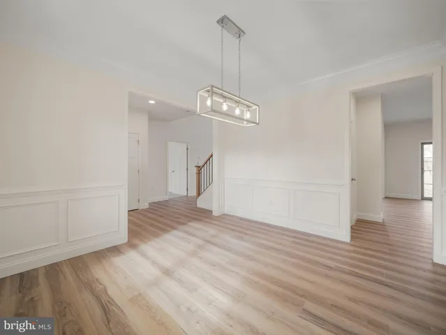a view of empty room with wooden floor and window