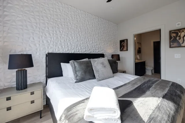 a bedroom with a large bed and a flat tv screen on dresser