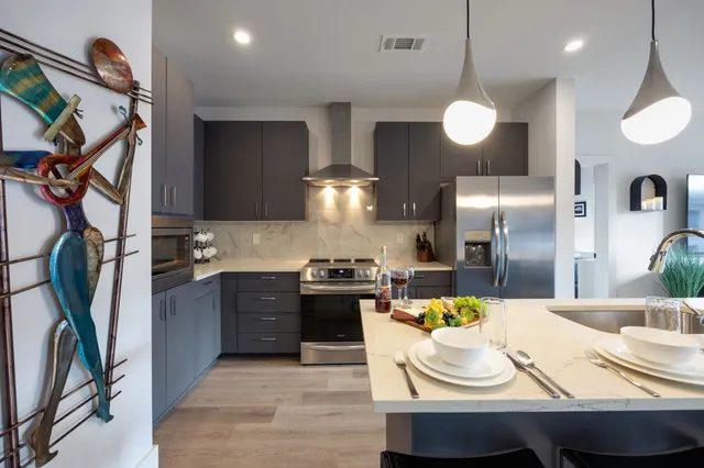 a kitchen with stainless steel appliances granite countertop a sink a stove and refrigerator