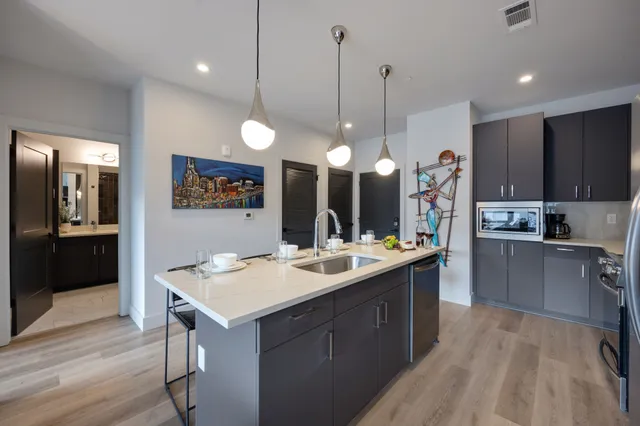a kitchen with a sink a counter top space stainless steel appliances and cabinets