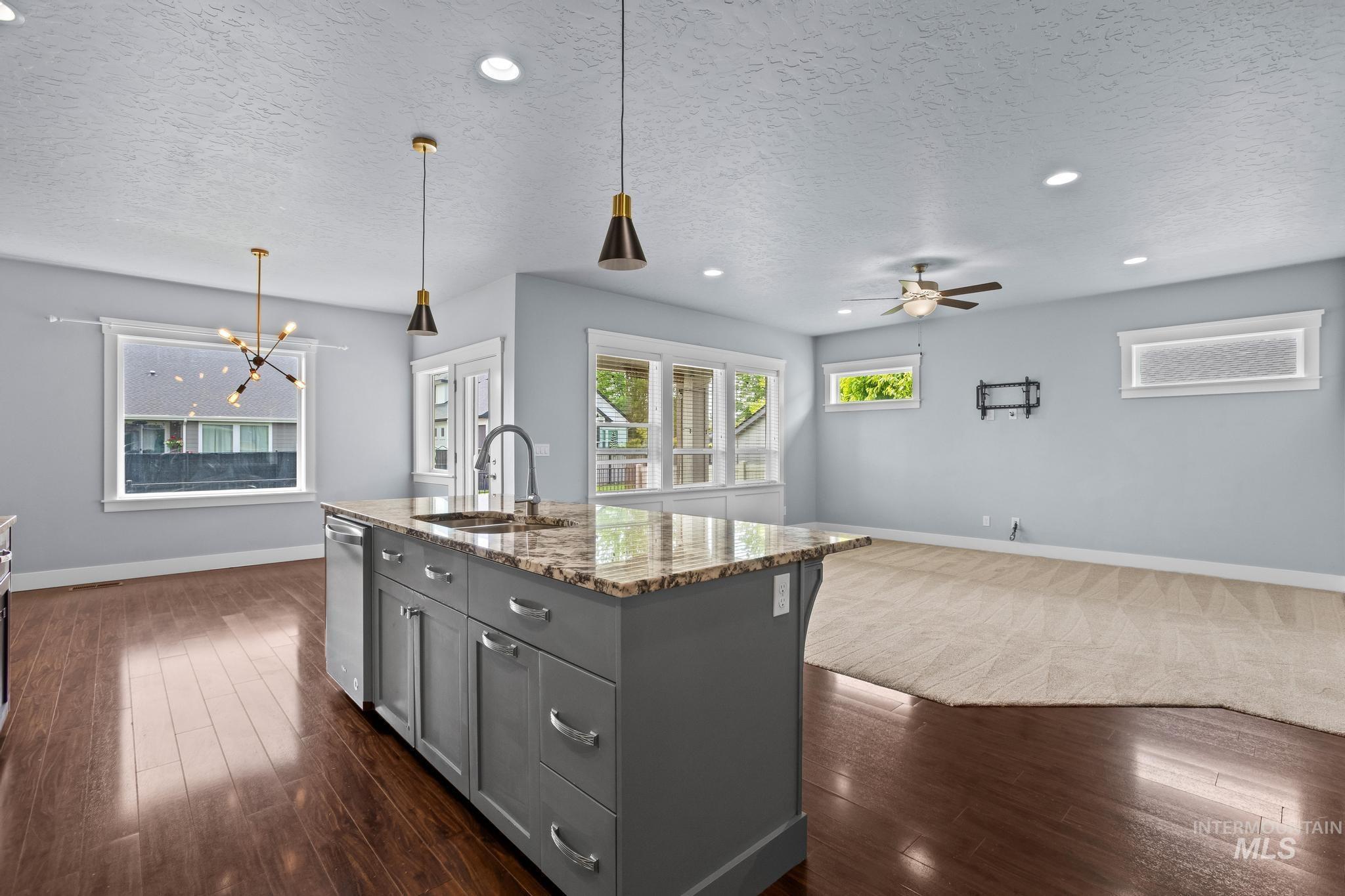 2681 East Rhyolite Court Nampa, ID 83686 - Photo 15 of 48 Spacious open-concept interior featuring a central island with a sink and stone countertop
