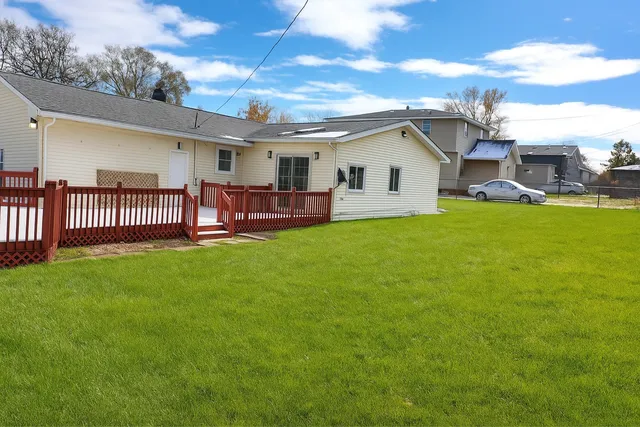 a view of a house with a yard and deck