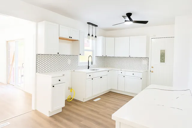 a kitchen with white cabinets and white appliances