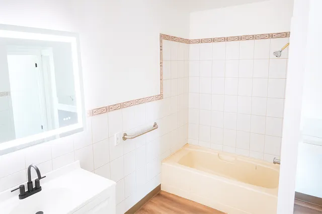 a bathroom with a tub a sink and a window