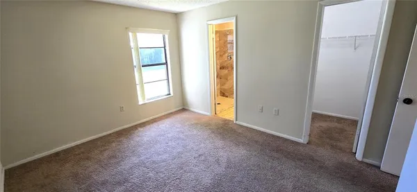 an empty room with windows and closet