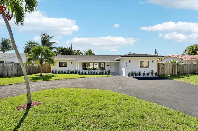 a front view of a house with a garden and yard