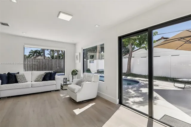 a living room with furniture and large windows